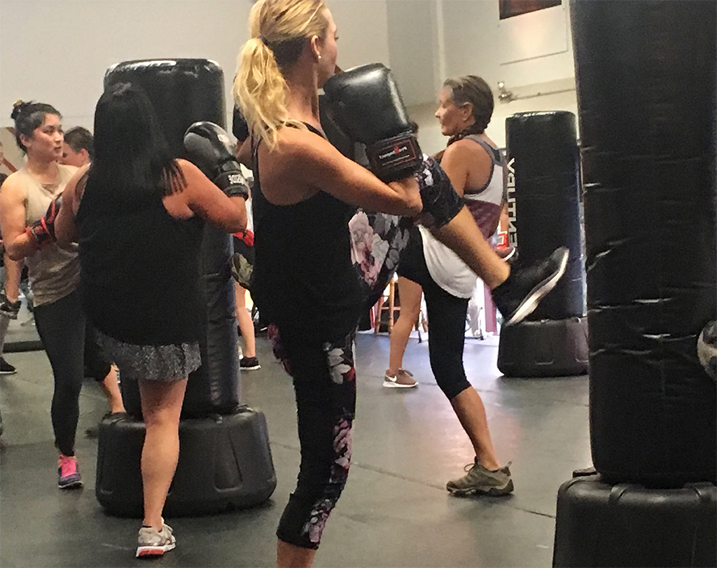 women kicking heavy bags