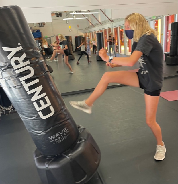 Young girl kicking heavy bag